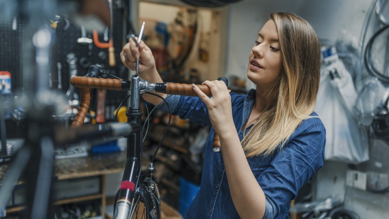 Bike repair shop with female worker making repairs